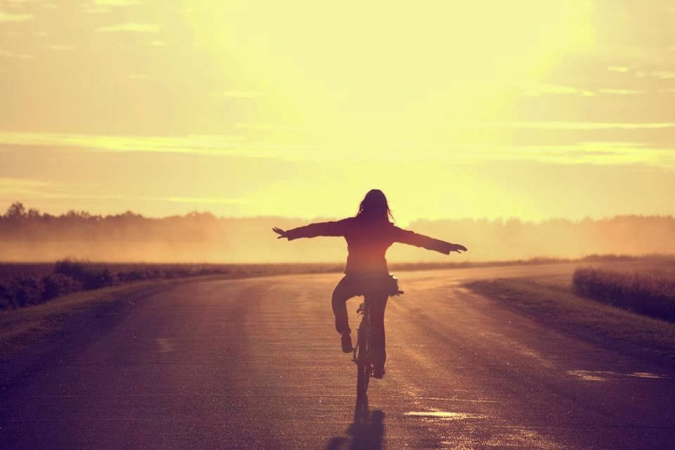 두 손을 옆으로 들고 자전거를 타는 사진