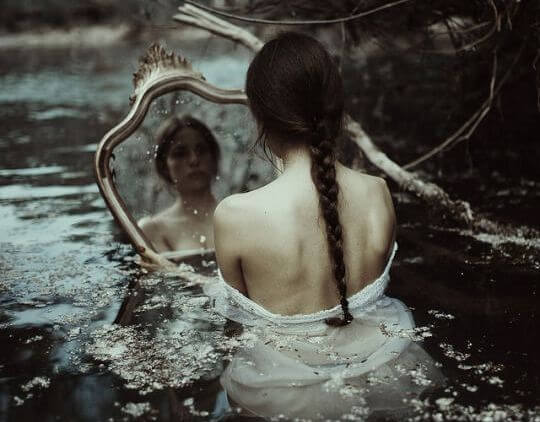 물 속에서 거울을 보고 있는 여자 사진