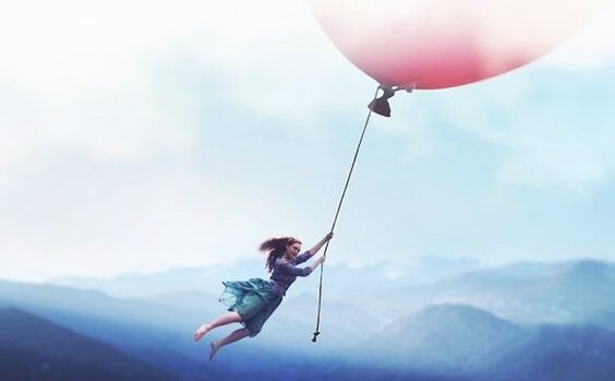 엄청 큰 핑크 풍선에 매달려 날아가는 여자 사진