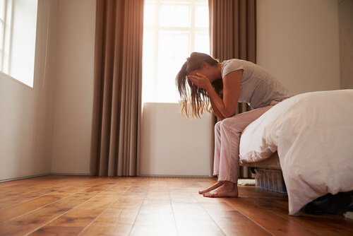침대에 걸터앉아 울고 있는 듯한 여자 사진: 질 경련
