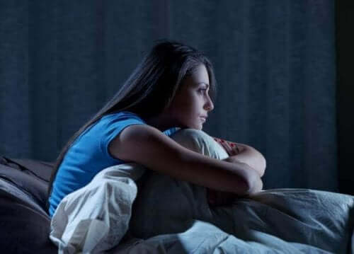 불면증 약리 치료: 정의 및 유형 - 침대에 웅크리고 있는 여자
